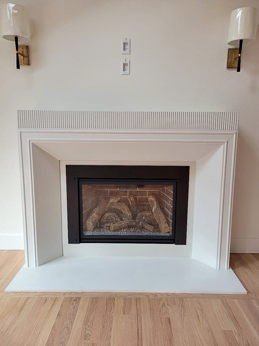 Clean modern fireplace surround in cream with minimalist stepped molding and linear crown detail.