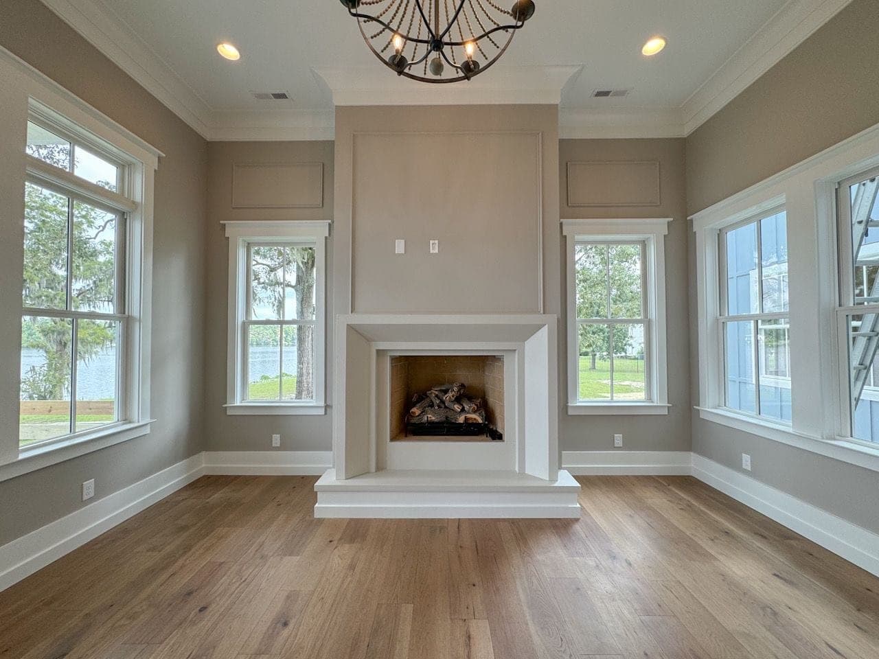 Minimalist cast-stone fireplace surround with clean lines in waterfront great room.