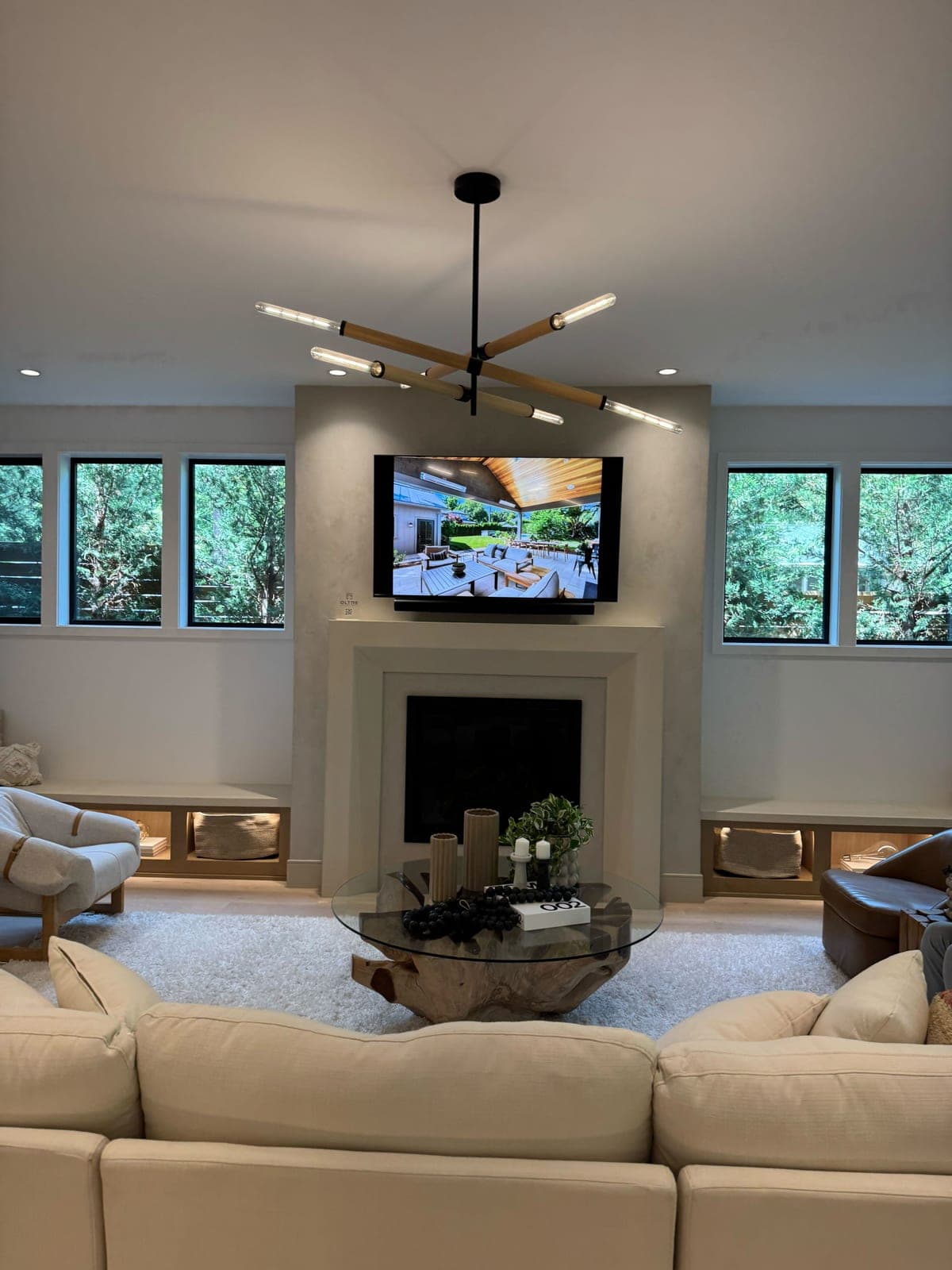 Minimalist cast-stone fireplace surround in light cream with clean rectilinear lines in luxury modern great room.