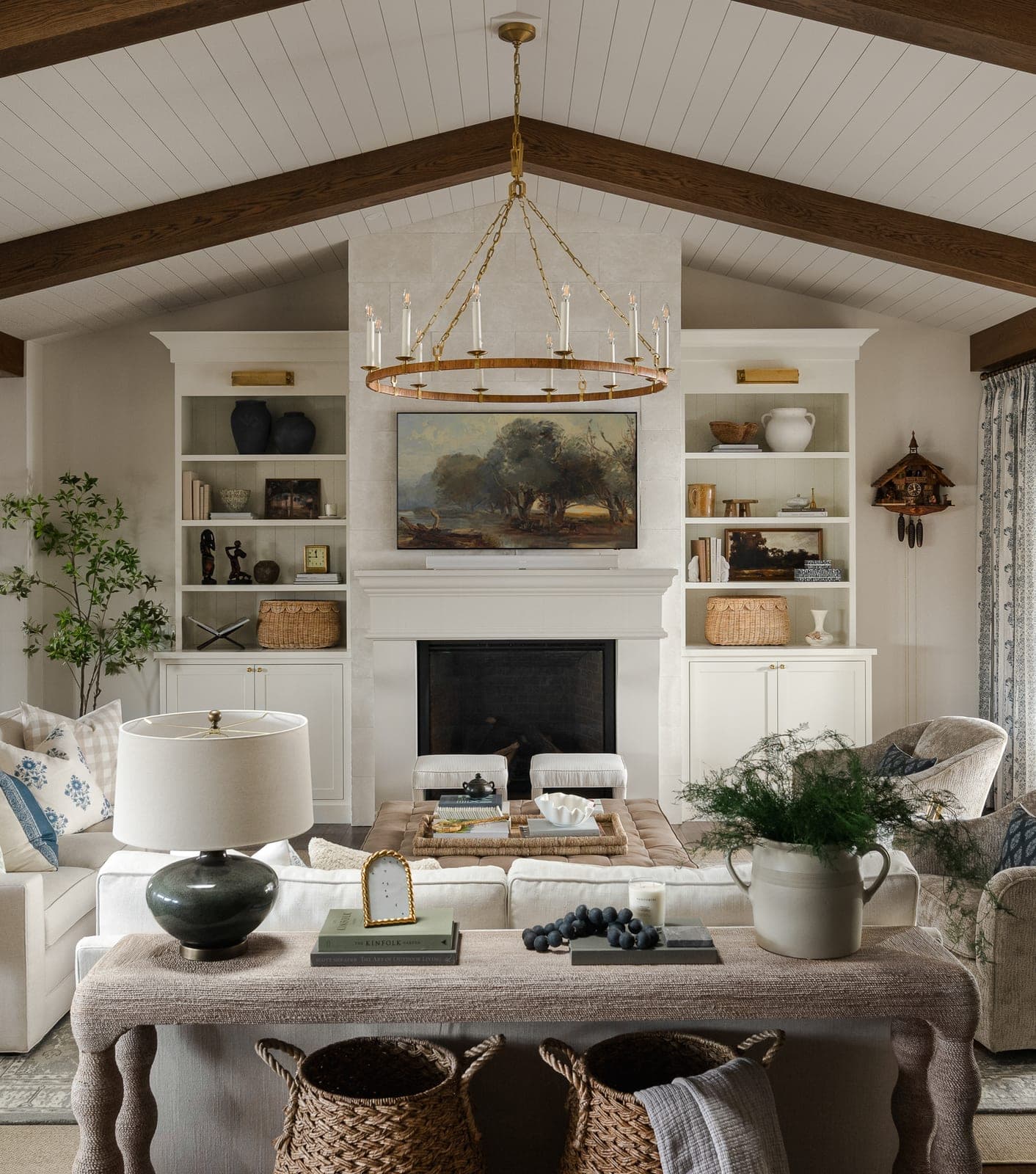 Elegant great room with cream cast-stone fireplace surround, built-in shelving, and transitional styling.