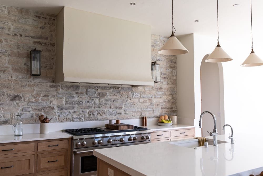 Modern kitchen with stacked stone backsplash, no fireplace surround visible.