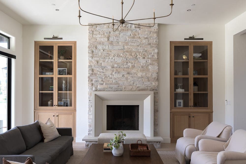 Clean-lined fireplace surround with stacked stone chimney breast anchors contemporary living space.