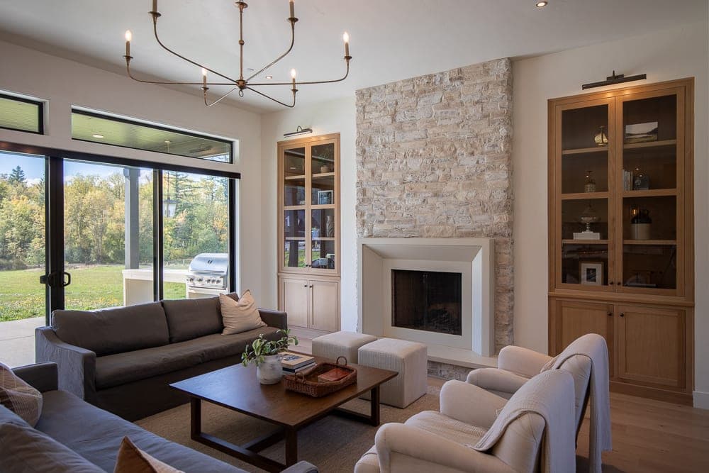 Modern transitional living room with clean-lined fireplace surround and stacked stone accent wall.