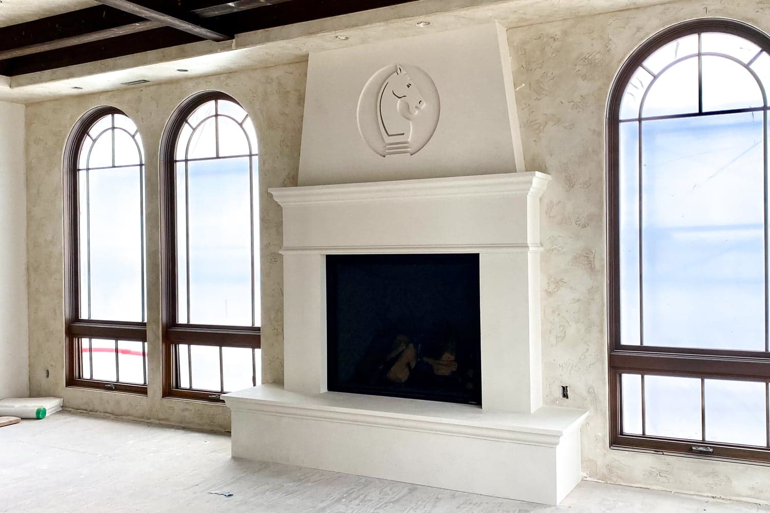Lake Shore Party Home — oversized custom mantel with recessed cast logo over the firebox.